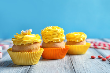Tasty colorful cupcakes on wooden table