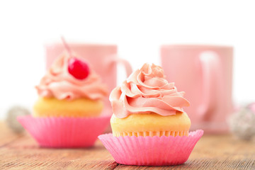 Delicious vanilla cupcake on table
