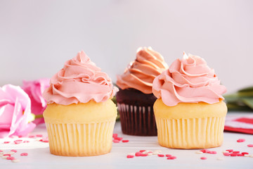 Delicious vanilla cupcakes on table