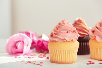 Delicious vanilla cupcake on table