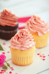 Delicious vanilla cupcake on table