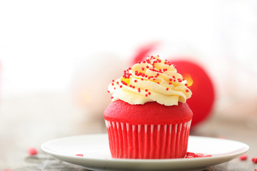Plate with delicious red velvet cupcake on table