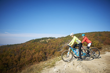 Obraz premium Two female cyclist enjoying the beautiful scenery while out mountain biking.