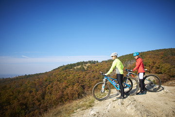 Obraz na płótnie Canvas Two female cyclist enjoying the beautiful scenery while out mountain biking.