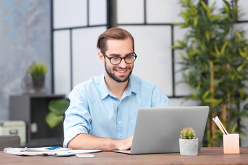 Young man using laptop in office