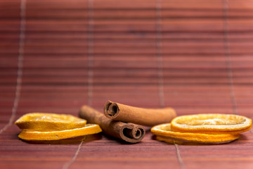 Dried orange slices on bamboo background arranged with cinnamon