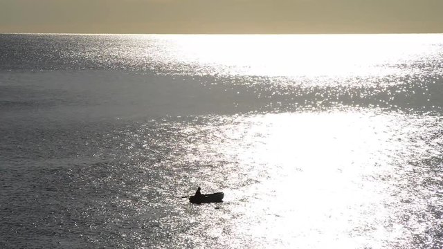 pescatore in mezzo al mare alle prime luci del giorno