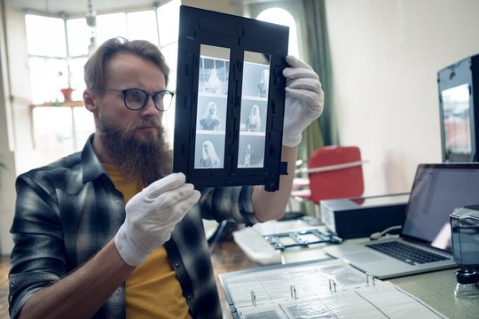 Photographer looking at negatives in frame