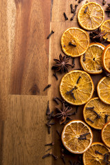 Dried orange slices on a wooden background arranged with cinnamon and anis