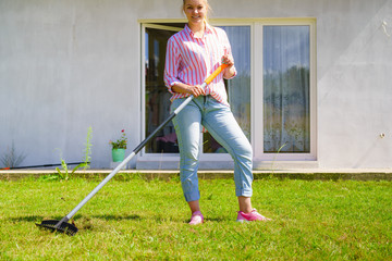 Woman using rake to clean up garden