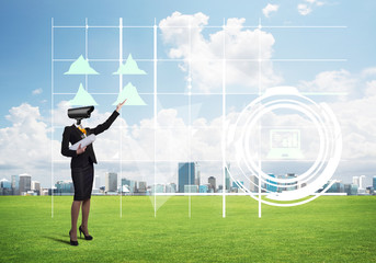 Camera headed woman standing on green grass against modern cityscape