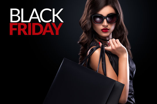 Shopping woman holding grey bag on dark background in black friday holiday