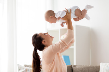 happy mother playing with little baby boy at home