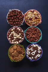 Dry breakfast, granola, muesli on a black background, vertically, top view, copyspace, flat lay