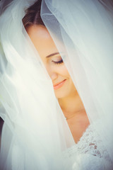 tender happy bride in a veil, a happy woman in a wedding dress, a white veil covers her face, gentle and warm