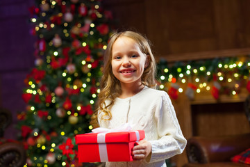 happy child girl with a magic Christmas gift