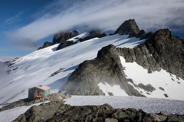 A small hut nestled amongst mountain peaks 