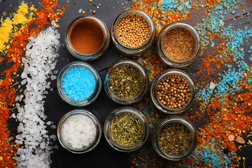 Set of spices on dark grey background. Glass jars
