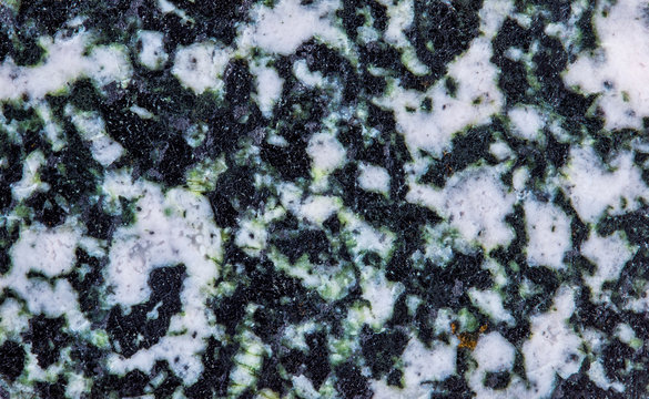 Gabbro mineral stone texture pattern macro view. greenish dark-colored coarse-grained magmatic plutonic rock, gabbroid family. contains pyroxene plagioclase and minor amounts of amphibole and olivine.
