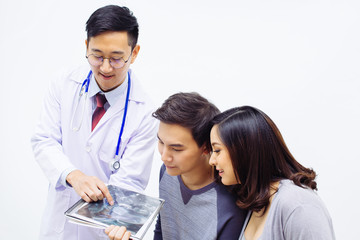 Gynecologist or Obstetrician Physician showing ultrasound photo to a couple of pregnant woman and husband