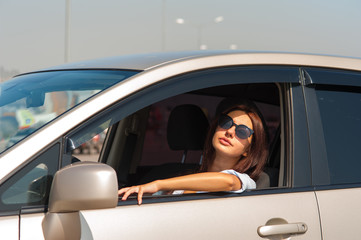 Beautiful business woman in sunglasses in the car