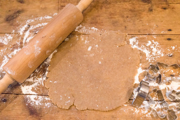 Christmas Raw Cookie Dough With Flour, Rolling Pin and  Cookie Cutters On An Wooden Plate
