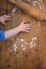 Child Hands Preparing Christmas Raw Cookie Dough With Flour, Rolling Pin and  Cookie Cutters On An Wooden Plate