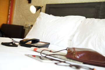 Telephone on bed in hotel room