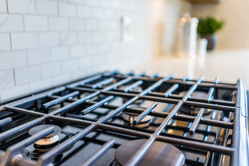 Macro closeup of brand new, modern gas stove on countertop in kitchen