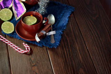 Christmas tea on wooden table with lime and candy canes.