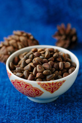 Fresh and ripe pine or cedar nuts in a bowl over blue background.