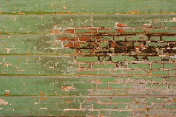 Old green weathered shabby brick wall with damaged plaster background texture