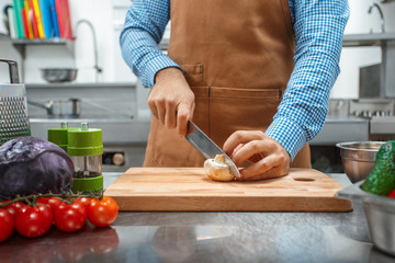 The chef in brown apron cooking in a restaurant kitchen