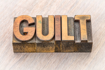 guilt word abstract in wood type