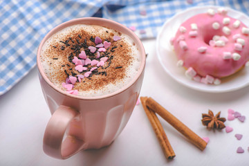rose mug of hot chocolate on the white table with rose donut and marshmallows.