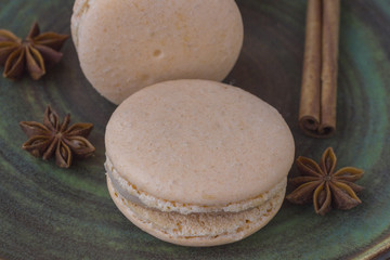 Sweet macarons and anise star on a green background.  Close-up.