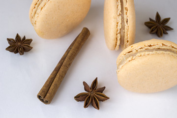 Sweet macarons, spices anise and cinnamon sticks on white background