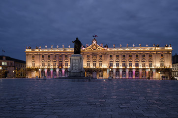 Obraz premium Square Stanislas in Nancy in the evening. In the center stands a monument to Stanislas. In the background there is a Town Hall building.