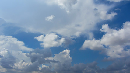 White fkuffy small clouds on the light-blue sky