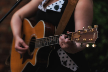 Fototapeta premium Closeup of a woman's hands playing guitar