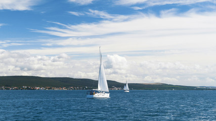 Fototapeta na wymiar Sailing. Ship yachts with white sails in the Sea. Luxury boats. Boat competitor of sailing regatta.