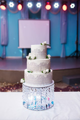 A beautiful three-tiered cake with a crystal.