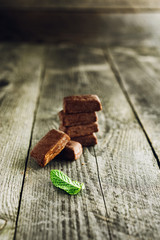 Pile of chocolate pieces on wooden background