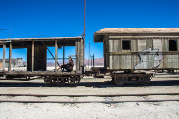 Fototapeta na wymiar Girl on the old railway in Salar de Uyuni (salt flat), Bolivia