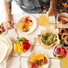 Mexican food hands of woman with tattoo eating