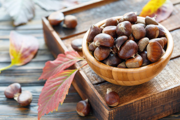 Ripe chestnuts in a wooden bowl.
