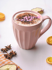 rose mug of hot chocolate on the white table with rose donut and marshmallows.