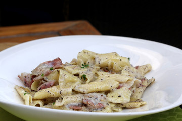 Creamy pasta with bacon and truffles. Traditional food in Slovenia and Croatia. Selective focus. 