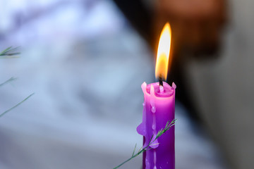 One purple candle with melting wax burning, high angle view