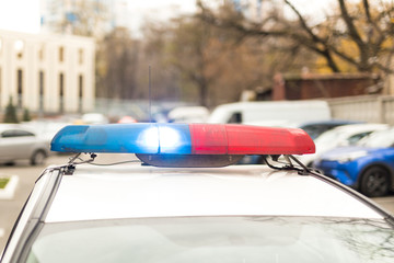 Roof of a police patrol car with flashing blue and red  lights, sirens and antennas